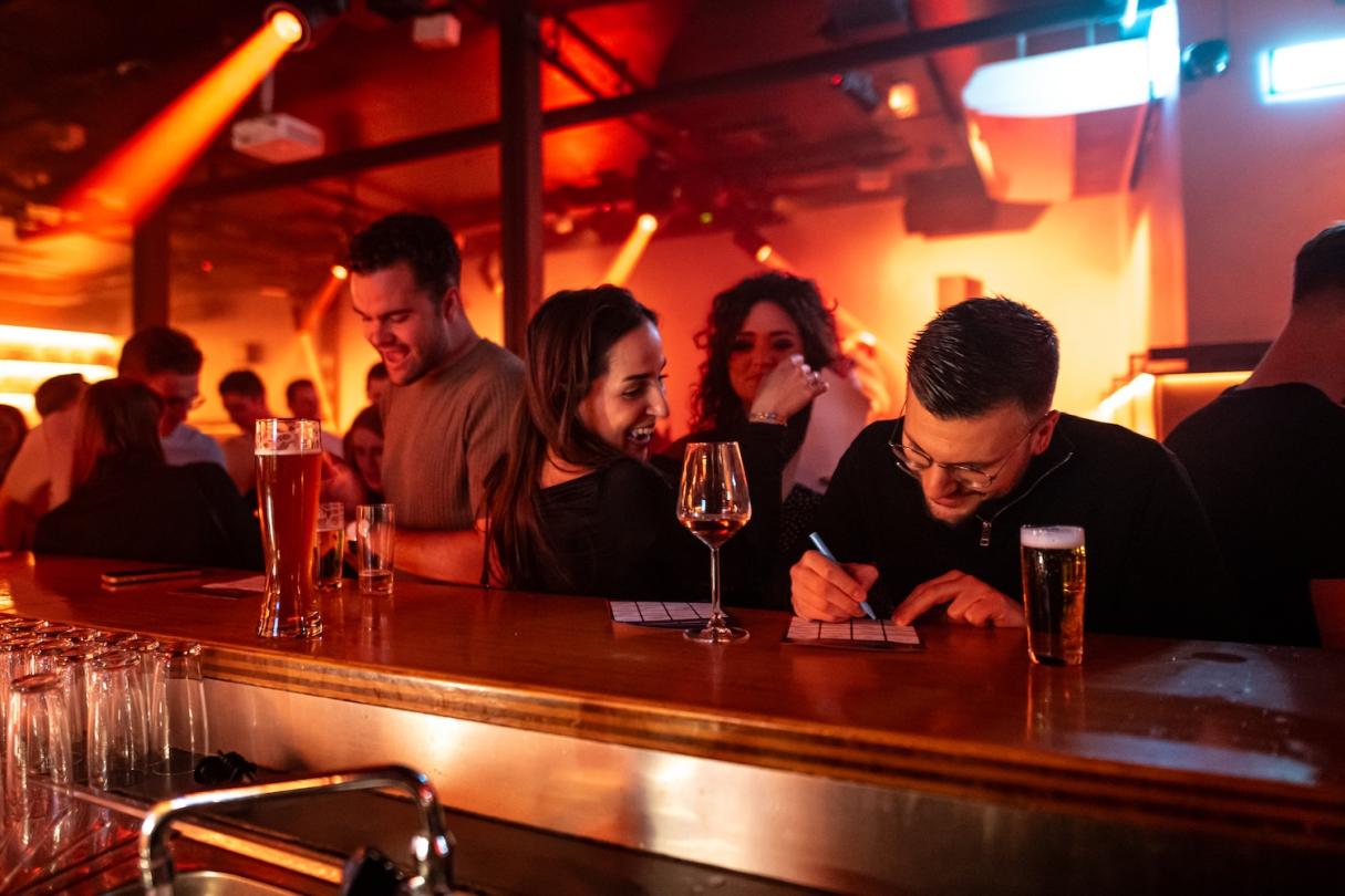 Des amis remplissent leur carte de bingo au comptoir d’un café